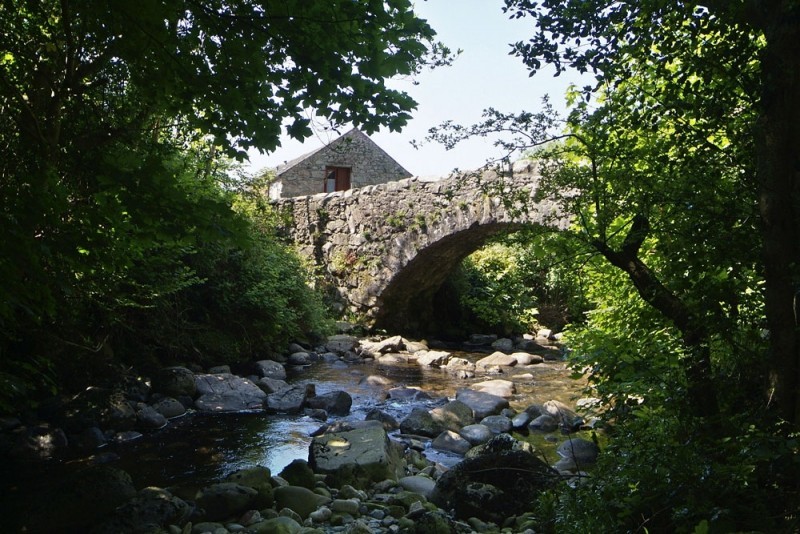17th Century Packhorse Bridge over the tumbling Whillan Beck and Whillan Beck Cottage in the background